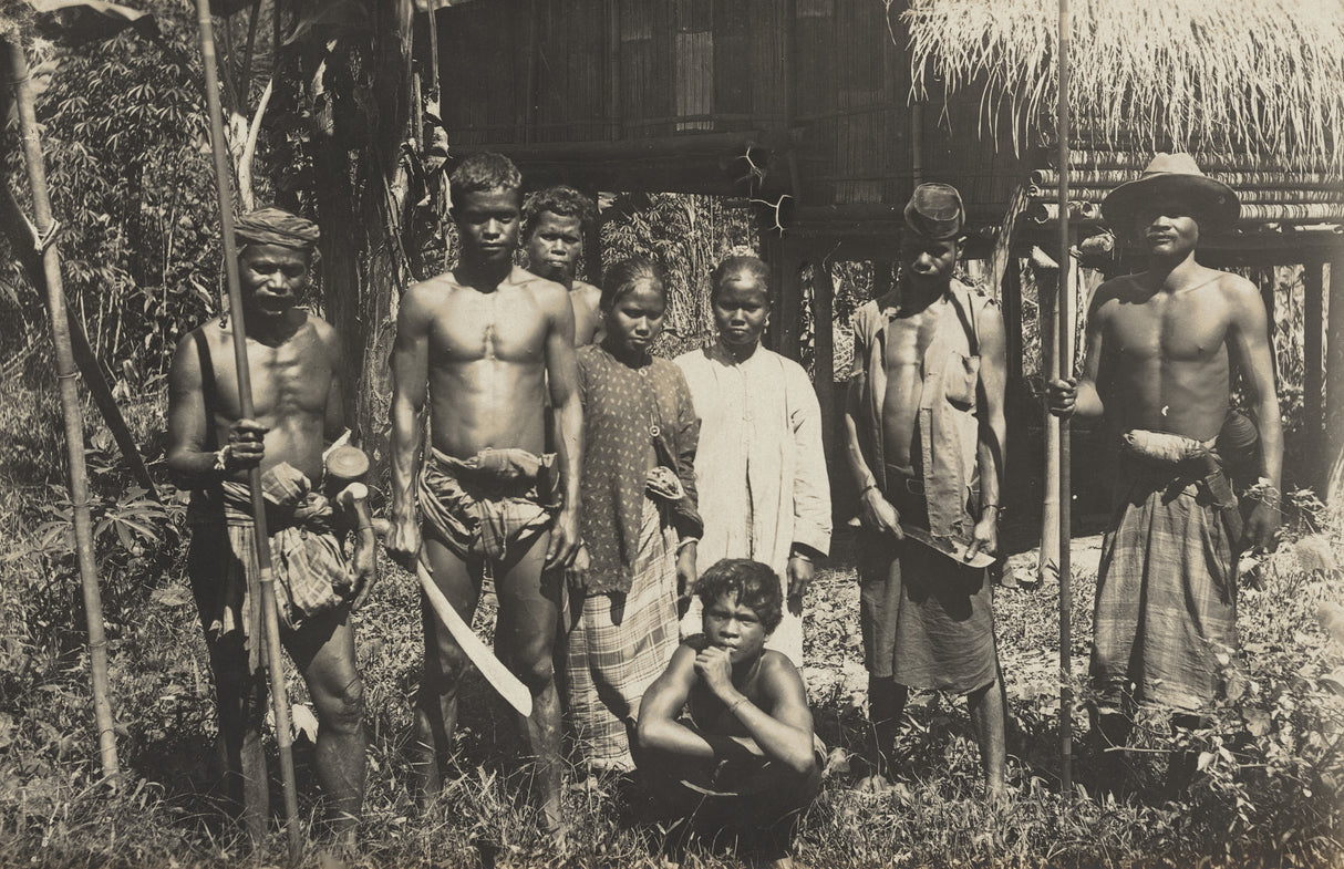 Black-and-white group portrait of Dayak people in Borneo with spears and traditional dress, 1940s