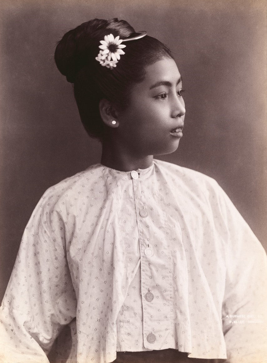 1890s studio portrait of a young Burmese woman by Philipp Klier, wearing a patterned blouse with flower in her hair