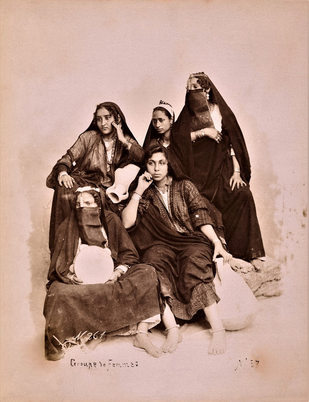Sepia studio portrait of veiled and unveiled Middle Eastern women, late 19th century