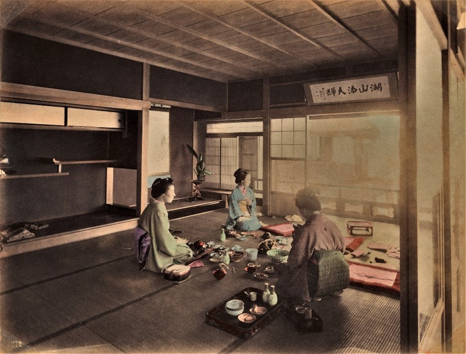 Meiji-era hand-colored photo of three women in a Japanese tea house sharing a meal or tea ceremony