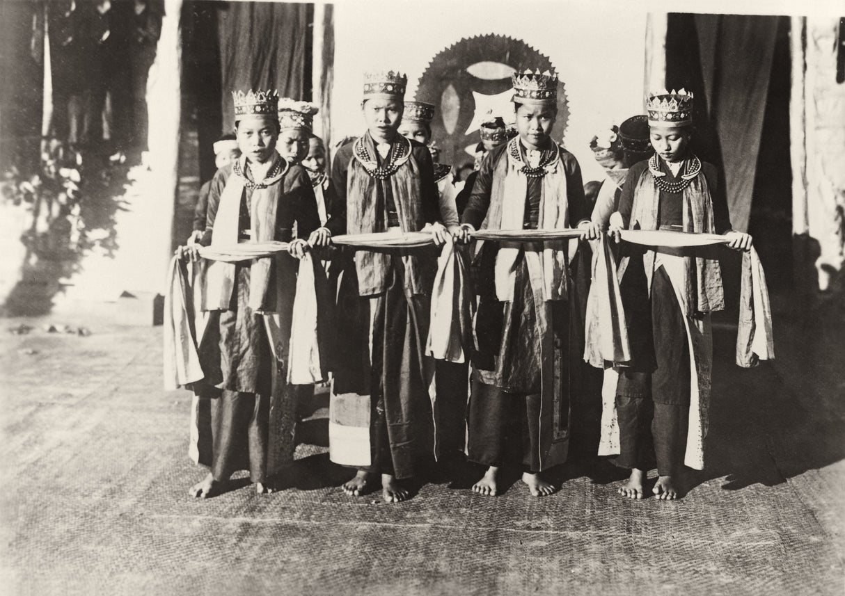 Group of young Vietnamese women in ceremonial crowns and robes holding cloths during a traditional dance, c. 1930s