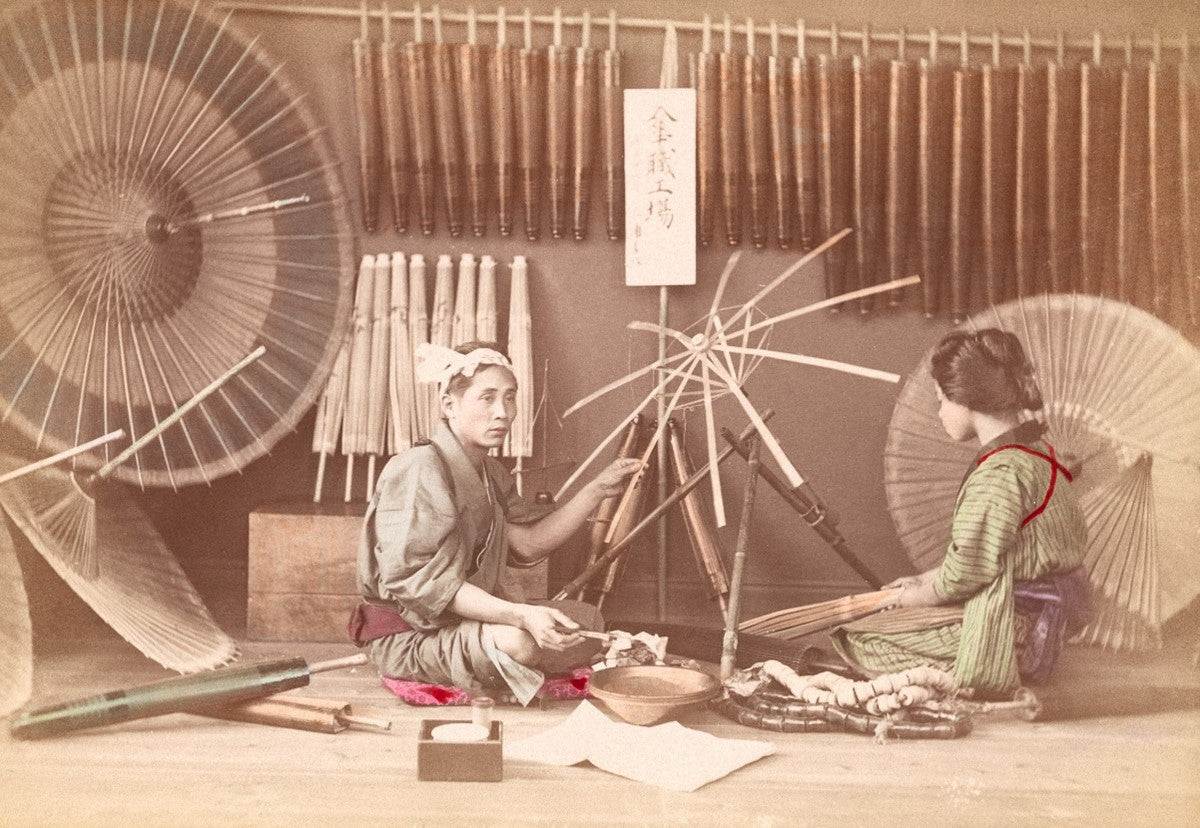 Hand-colored Meiji-era photograph of Japanese women crafting umbrellas