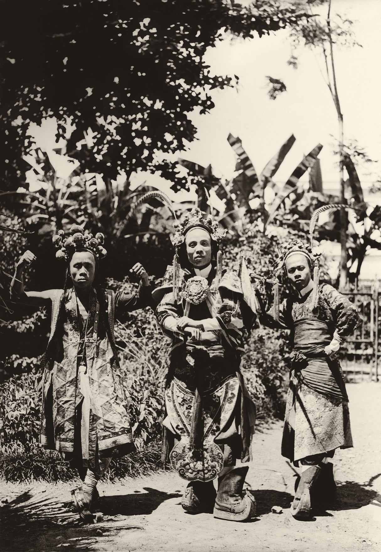 Black-and-white photograph of three Vietnamese Hát Bội opera performers in traditional theatrical dress and headdress