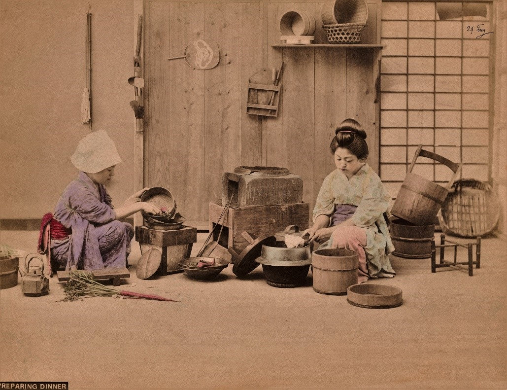 Hand-colored Meiji-era photograph of a Japanese woman slicing daikon radish in a traditional setting