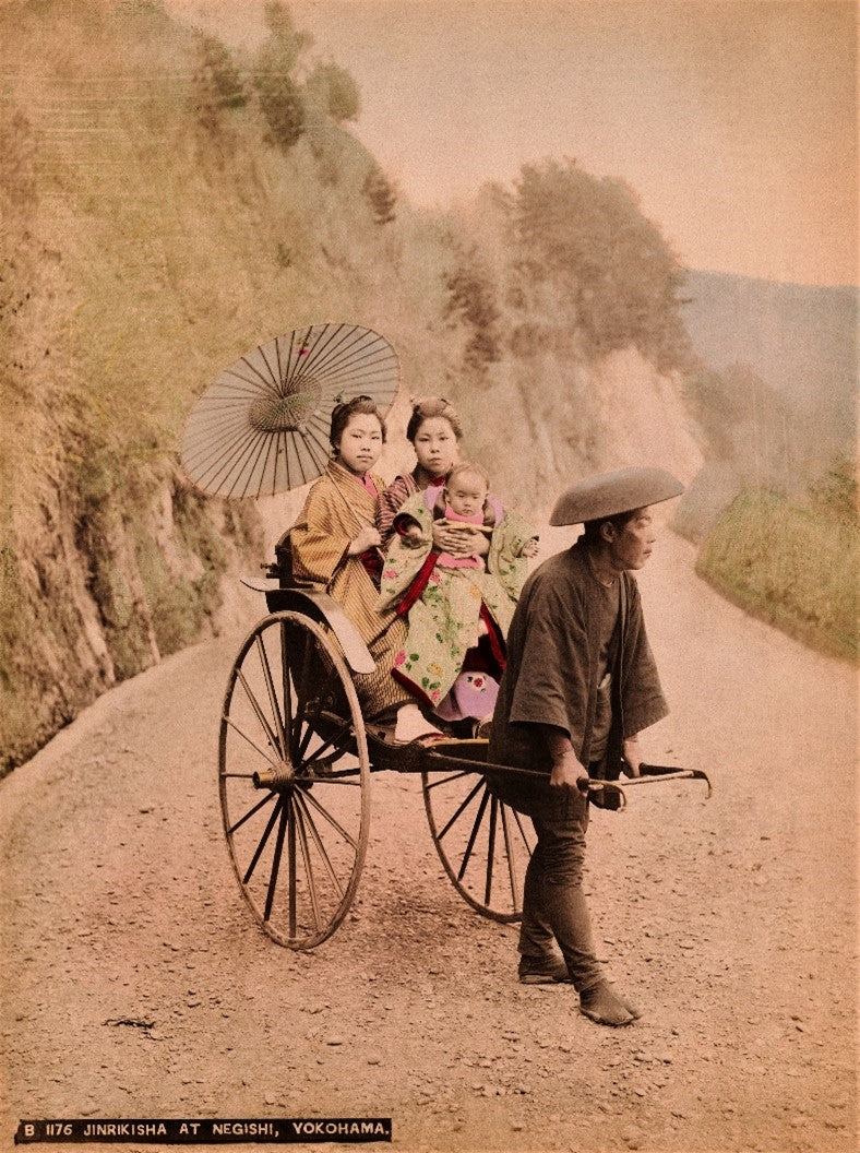 Meiji-era hand-colored photo of two women and a child in a jinrikisha in Yokohama, Japan