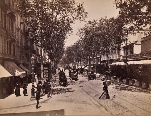 Sepia photograph of Avenue de la Gare in Nice with pedestrians and horse-drawn carriages, circa 1890