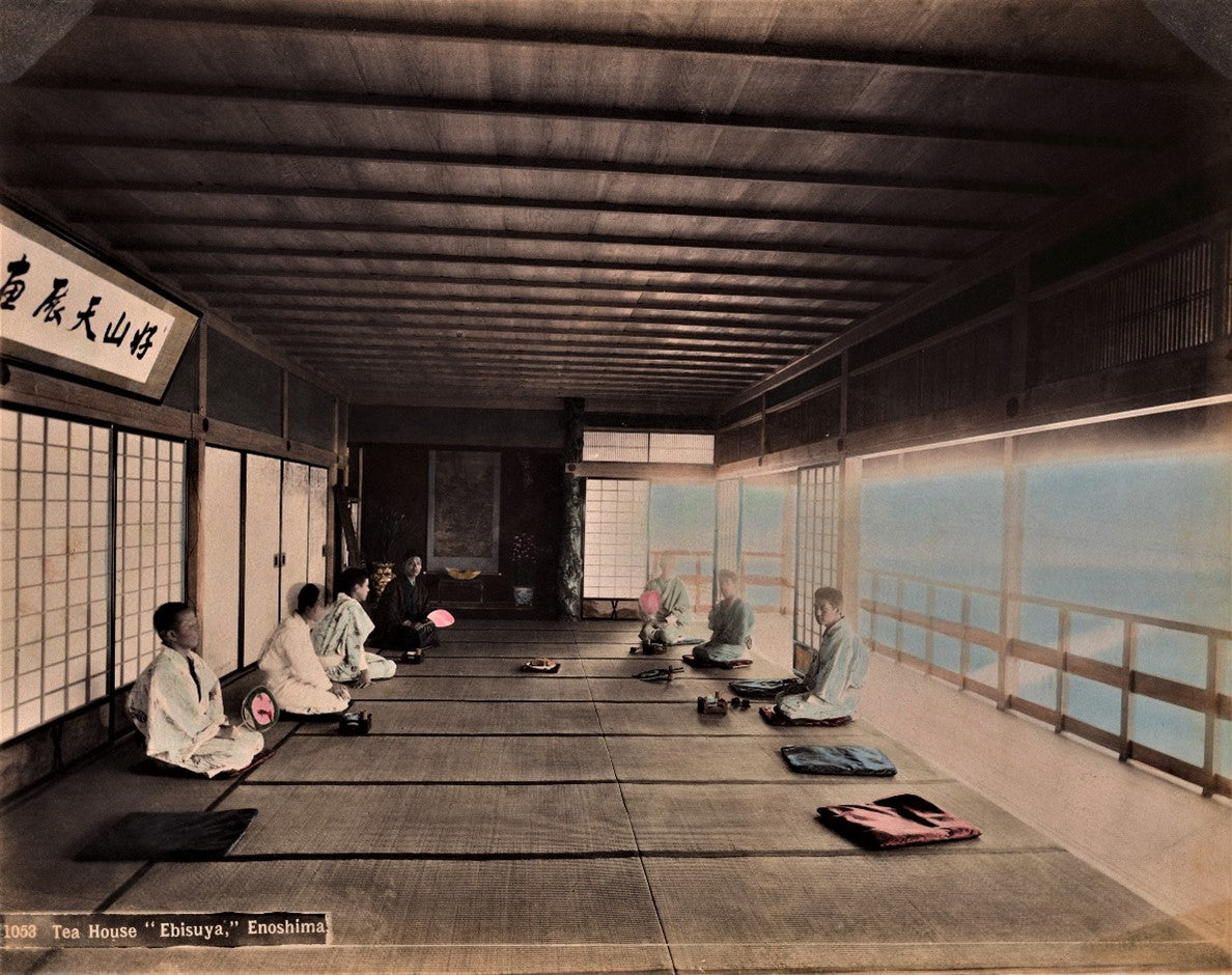 1890s hand-colored photograph of guests seated in a traditional Japanese tea house overlooking the sea
