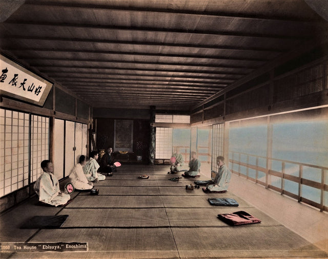 1890s hand-colored photograph of guests seated in a traditional Japanese tea house overlooking the sea