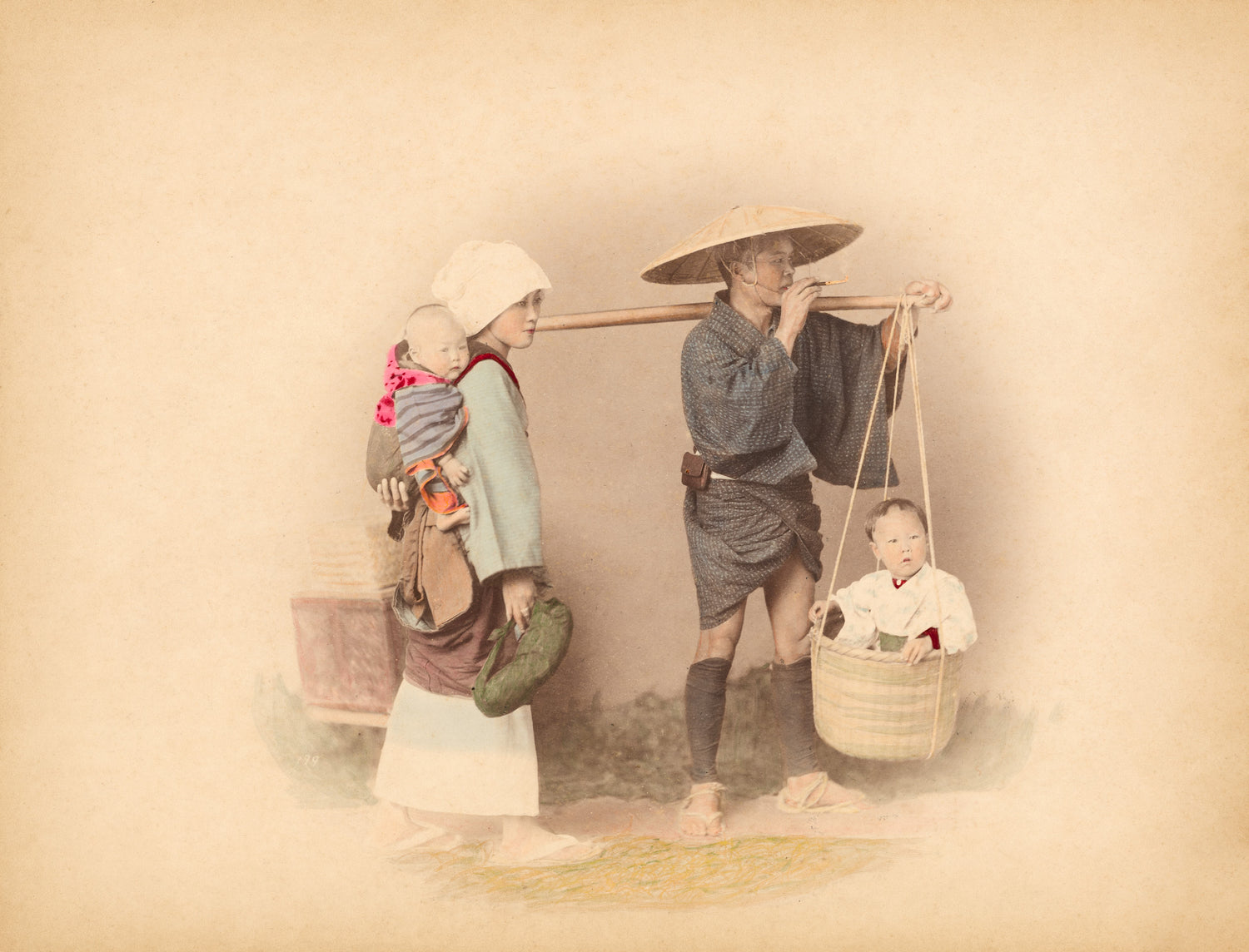 Hand-colored Meiji-era photograph of a Japanese family with two children, by Felice Beato. Father smoking a pipe, mother carrying a baby on her back.