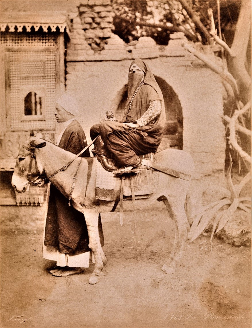 Sepia photograph by Zangaki of veiled woman riding a donkey, Middle East, late 19th century