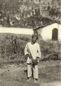 Man playing lusheng pipe instrument in a rural landscape, northern Indochina, 1910s
