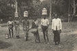 Black-and-white photo of rubber workers in Ceylon carrying latex vessels, early 20th century