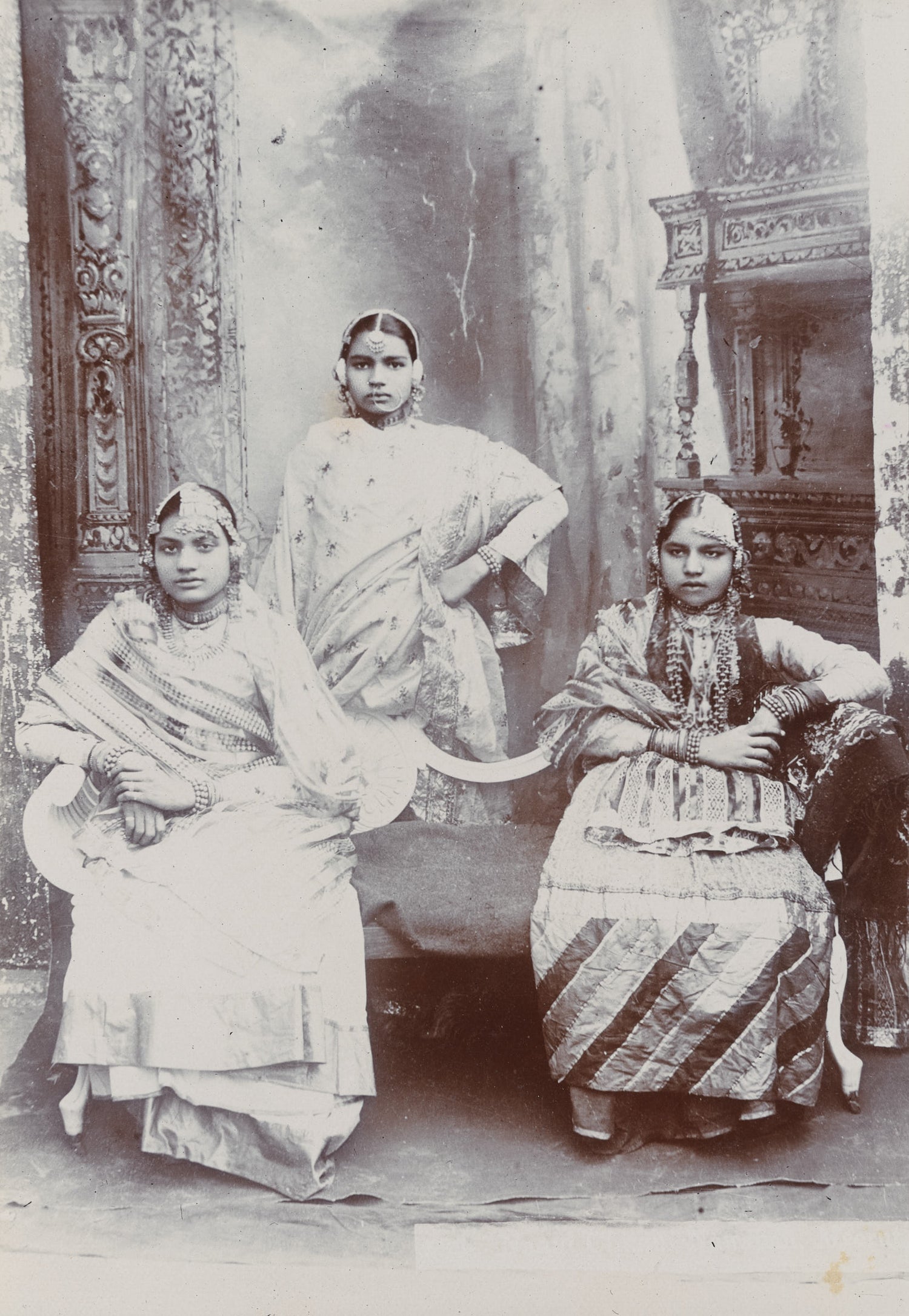 Black-and-white 1890s studio portrait of three Indian women in traditional dress and jewelry