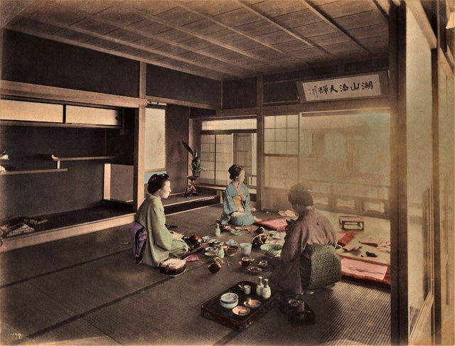 Meiji-era hand-colored photo of three women in a Japanese tea house sharing a meal or tea ceremony