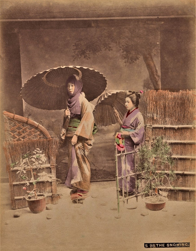 Hand-colored photograph of two Japanese women with parasols in winter garden, by Kusakabe Kimbei
