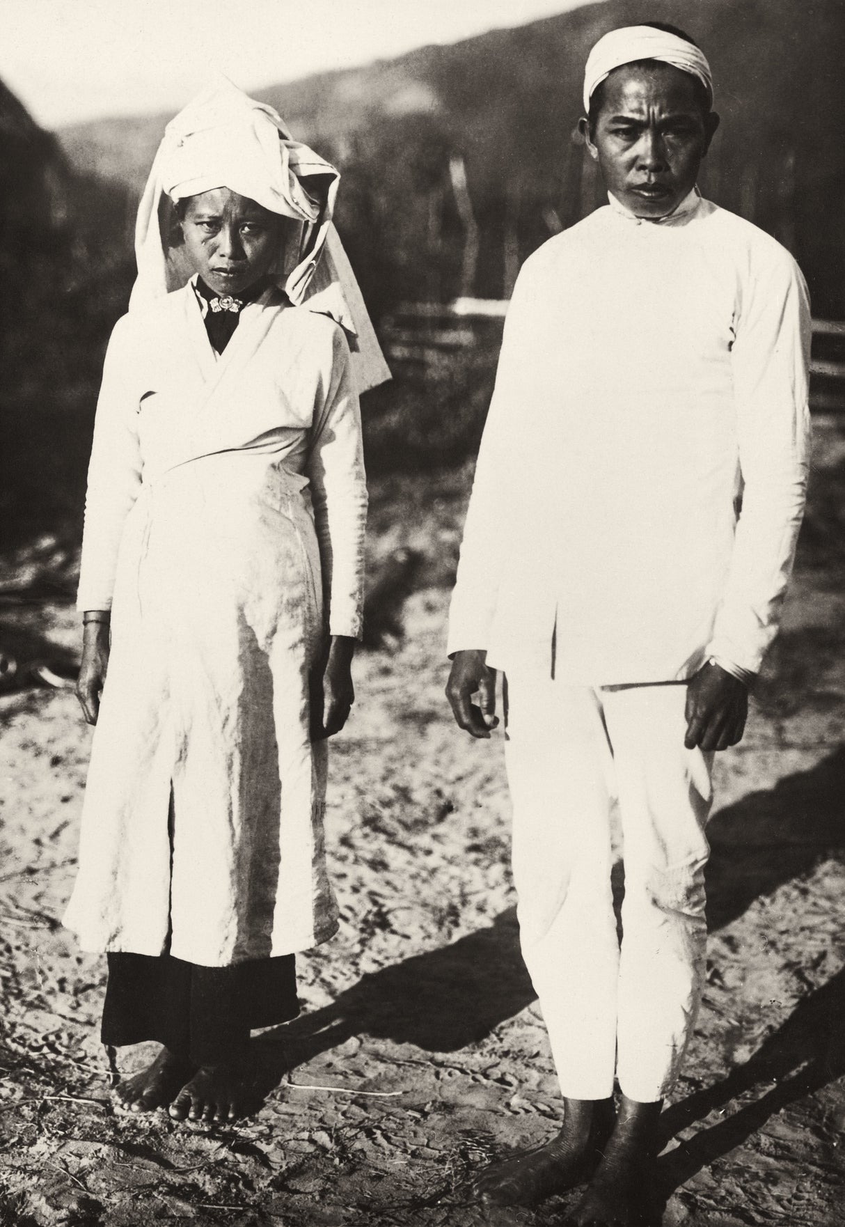 Black-and-white photo of a man and woman in white mourning garments, early 20th century, Northern Vietnam
