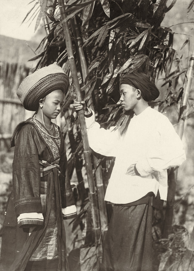 Ethnographic portrait of a young couple in traditional dress near bamboo, Yunnan–Indochina borderlands